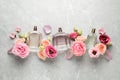 Flat lay composition of different perfume bottles and flowers on light grey marble background Royalty Free Stock Photo