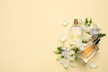 Flat lay composition with different perfume bottles and freesia flowers on yellow background, space for text Royalty Free Stock Photo