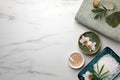 Flat lay composition with different spa products and flowers on white marble table. Space for text Royalty Free Stock Photo