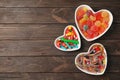 Flat lay composition with different yummy candies in heart shaped bowls and space for text Royalty Free Stock Photo