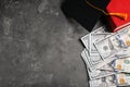 Flat lay composition with dollars and student graduation hat on stone background. Tuition fees concept Royalty Free Stock Photo