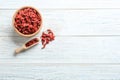 Flat lay composition with dried goji berries on white wooden table. Healthy superfood