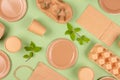 Flat lay composition with eco-friendly tableware and kraft paper food packaging on green background. Sustainable