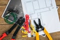 Flat lay composition with electrical tools and house plans on wooden background Royalty Free Stock Photo
