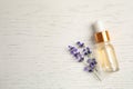 Flat lay composition with essential oil and lavender flowers on white wooden background. Space for text Royalty Free Stock Photo