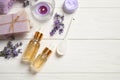 Flat lay composition with essential oil and lavender flowers on white wooden background. Space for text Royalty Free Stock Photo