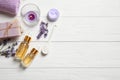 Flat lay composition with essential oil and lavender flowers on white wooden background. Space for text Royalty Free Stock Photo