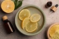 Flat lay composition with essential oil and lemons on grey textured table. Aromatherapy treatment Royalty Free Stock Photo