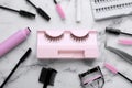Flat lay composition with false eyelashes and tools on white marble table Royalty Free Stock Photo