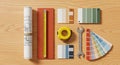 Flat lay of painting and decorating tools with color swatches, tape measure, ruler, and wrench on wooden surface Royalty Free Stock Photo