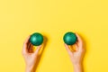 Flat lay composition female hands holding two green Christmas balls