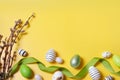 Flat lay composition with festively decorated Easter eggs and pussy willow branches on yellow background. Space for text Royalty Free Stock Photo