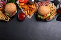 Flat lay composition with fresh bacon burgers and fries on table. Space for text Royalty Free Stock Photo