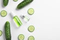 Flat lay composition with fresh cucumber, cosmetic bottles and space for text