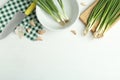 Flat lay composition with fresh green spring onions and garlic cloves on white table. Space for text Royalty Free Stock Photo