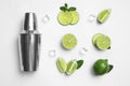 Flat lay composition with fresh juicy limes, ice cubes and cocktail shaker on background Royalty Free Stock Photo