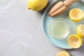 Flat lay composition with fresh lemons, juice and reamer on grey table. Space for text Royalty Free Stock Photo