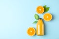 Flat lay composition with fresh orange juice in bottle and oranges with leaves on color background, space for text Royalty Free Stock Photo