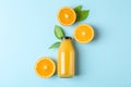 Flat lay composition with fresh orange juice in bottle and oranges with leaves on color background, space for text Royalty Free Stock Photo