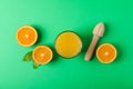 Flat lay composition with fresh orange juice, wooden juicer and oranges with leaves on color background, space for text Royalty Free Stock Photo