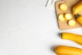 Flat lay composition with fresh ripe yellow zucchinis on white wooden table