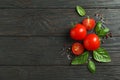 Flat lay composition with fresh tomatoes, salt, pepper and basil on wooden background, space for text