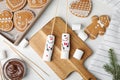Flat lay composition with funny snowmen made of marshmallows on white wooden table