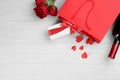 Flat lay composition with gift box and roses on white wooden background, space for text. Valentine`s Day celebration Royalty Free Stock Photo