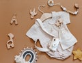 Flat lay composition with girl bodysuit, wooden camera and toys.