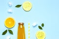 Flat lay composition with glass bottles of juice or fresh, slices of fresh lemon and orange, green leaves, ice cubes on Royalty Free Stock Photo