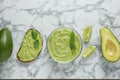 Flat lay composition with guacamole, sandwich and avocados on marble table