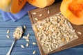 Flat lay composition with heap of pumpkin seeds on blue wooden table