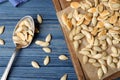 Flat lay composition with heap of pumpkin seeds on blue wooden table