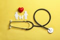 Flat lay composition with heart, stethoscope and paper silhouette of family on color background. Life insurance Royalty Free Stock Photo