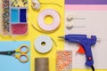 Flat lay composition with hot glue gun and handicraft materials on color background