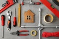 Flat lay composition with house figure and repair tools on stone table