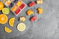 Flat lay composition with ice cube tray and fresh fruits on grey background. Royalty Free Stock Photo