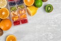 Flat lay composition with ice cube tray and fresh fruits on light background. Royalty Free Stock Photo