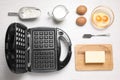 Flat lay composition with ingredients and Belgian waffle maker on white table