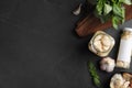 Flat lay composition with jars of pickled garlic on dark table