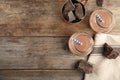 Flat lay composition with jars of tasty chocolate milk and space for text on wooden background. Royalty Free Stock Photo