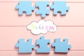 Flat lay composition with jigsaw puzzle pieces and word Autism on pink wooden background Royalty Free Stock Photo