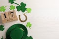 Flat lay composition with leprechaun hat and block calendar on white wooden table, space for text. St Patrick`s Day celebration Royalty Free Stock Photo