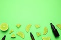 Flat lay composition with lime essential oil on green. Space for text Royalty Free Stock Photo