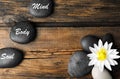 Flat lay composition of lotus flower and stones with words Mind, Body, Soul on wooden background. Zen lifestyle Royalty Free Stock Photo