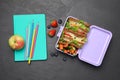 Flat lay composition with lunch box of tasty healthy food and school stationery on grey table Royalty Free Stock Photo