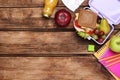 Flat lay composition with lunch box, tasty healthy food and school stationery on wooden table. Space for text Royalty Free Stock Photo