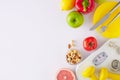 Flat lay composition made of scales, dumbbells, tape measure, plate with cutlery, vegetables, fruits and nuts Royalty Free Stock Photo