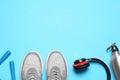 Flat lay composition with man`s sneakers and fitness items on blue background, space for text