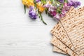 Flat lay composition of matzo and flowers on wooden background. Passover Pesach Seder